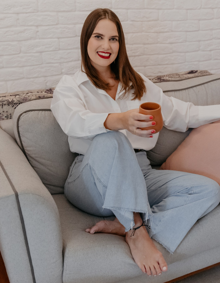 Letícia de branco no sofá da clínica